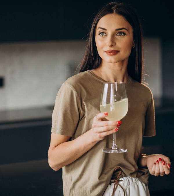 A person holding a glass of white wine