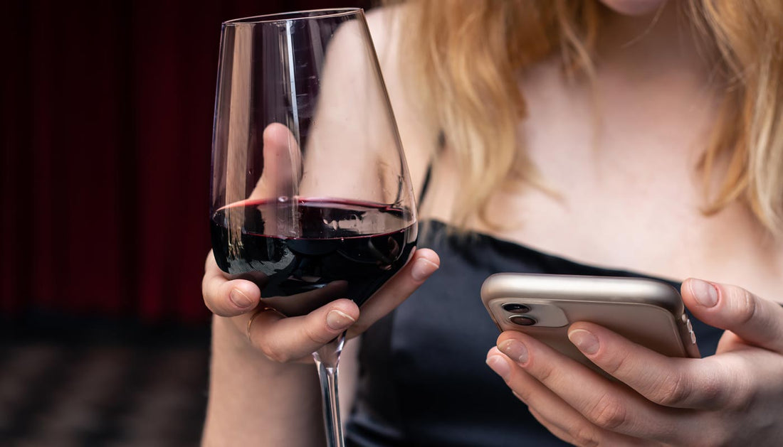 Best wine app options shown on a phone next to a glass of Portuguese red wine
