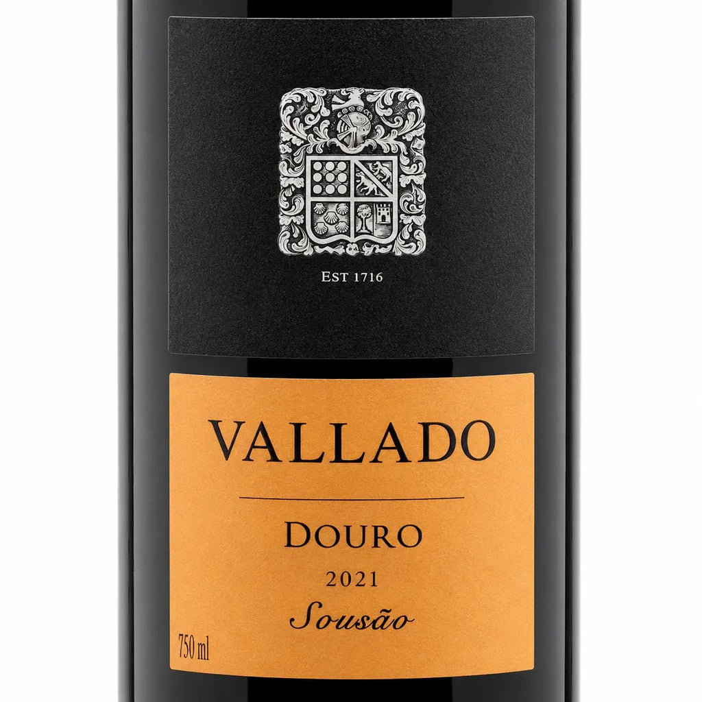 Front view of a Vallado Sousão Douro 2021 Sousão wine bottle, showing a black label with a silver crest and a warm orange label below.
