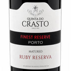 Close-up of a Quinta do Crasto wine bottle label, showing 'Finest Reserve Porto' and 'Matured Ruby Reserva' on a white and black label.