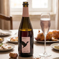 Bottle of Baga wine with a glass of sparkling wine on a dining table with food.