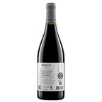 A bottle of Manoella Douro red wine with a dark glass body, gray foil capsule, and a white label showing the back details, set against a plain white background.