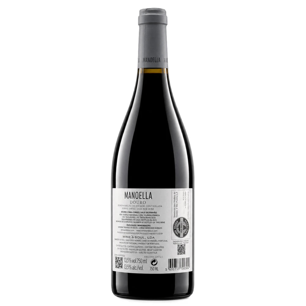 A bottle of Manoella Douro red wine with a dark glass body, gray foil capsule, and a white label showing the back details, set against a plain white background.