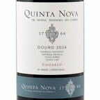 A close-up of a Quinta Nova wine bottle label, showing the white main label with black text and crest, plus a blue lower band with the brand name and vintage information.