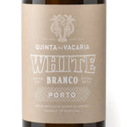 A close-up of a wine bottle label reading 'QUINTA DA VACARIA WHITE BRANCO EXTRA DRY EXTRA SECO PORTO', with a kraft-paper style beige label and dark brown bottle edges visible at the top and bottom.