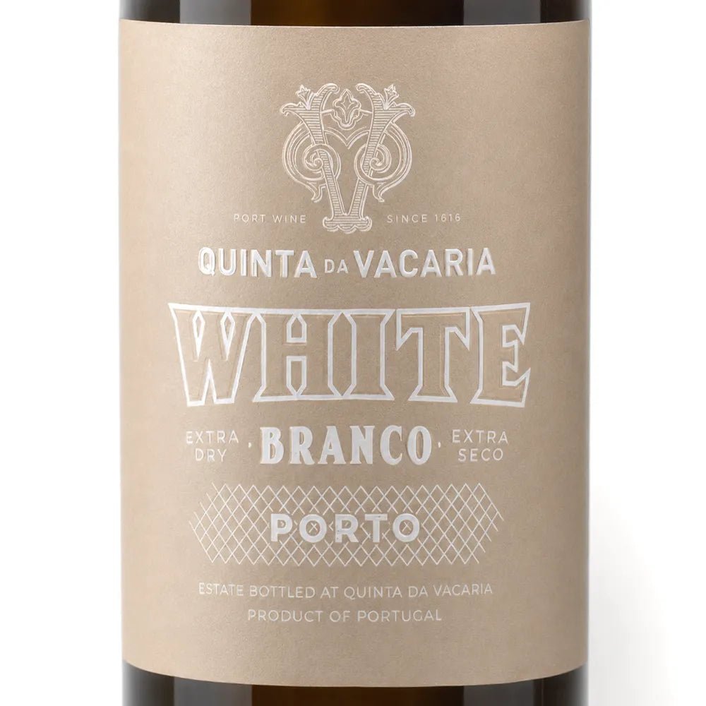 A close-up of a wine bottle label reading 'QUINTA DA VACARIA WHITE BRANCO EXTRA DRY EXTRA SECO PORTO', with a kraft-paper style beige label and dark brown bottle edges visible at the top and bottom.