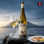 Oceánico white wine bottle with a glass and plate of food against a mountainous background