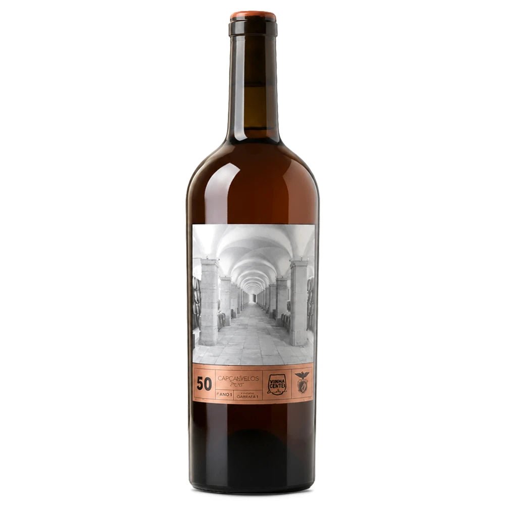 A dark brown glass bottle of wine with a white and black architectural label and a copper-colored band at the bottom, shown on a plain white background.