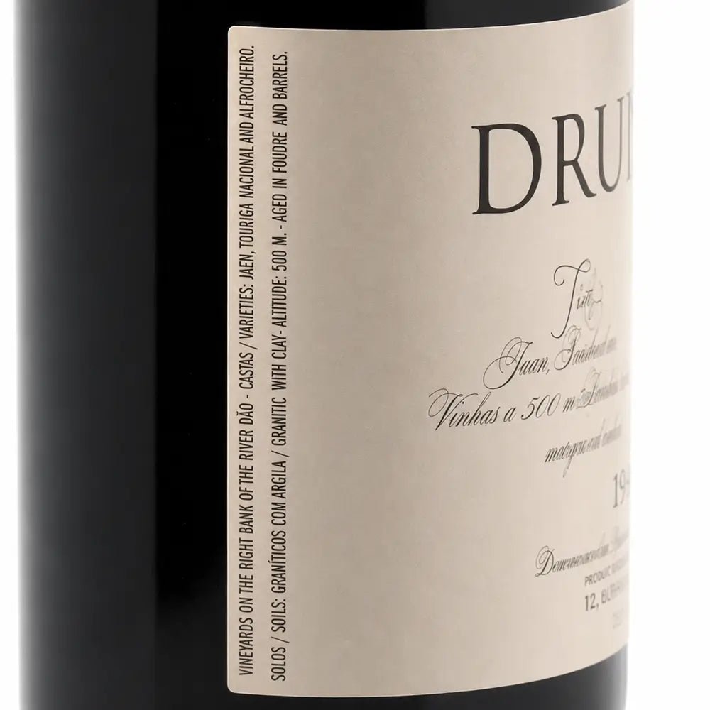 Close-up of a wine bottle label with the brand DRUIDA visible, showing part of the dark bottle and a cream-colored label with black text.