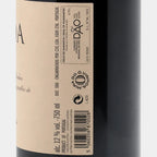 Close-up of a wine bottle label with the brand DRUIDA visible, showing part of the dark bottle and a cream-colored label with black text.