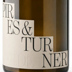 Close-up of a dark amber glass bottle with a cream-colored paper label featuring black serif text that reads 'PIRES & TURNER' .