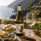 A bottle of Barbetto Vinhas do Lauce Non-Alcoholic White Wine, featuring an olive-green wine glass shape, a cream-colored foil top, and a white label with green grape illustrations on a Madeira setting 