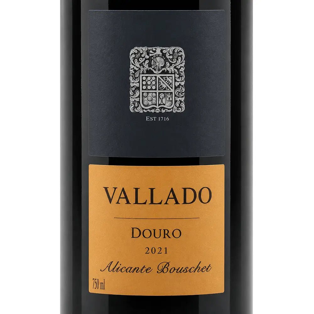 A close-up of a wine bottle label for Vallado-Alicante-Bouschet-2021, featuring a black upper section with a silver crest and a warm golden-brown lower label with black text.
