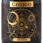 Close-up of a dark bottle label with gold celestial artwork and the text 'CÓDIGO' at the top and 'ØR1GEM' at the bottom.