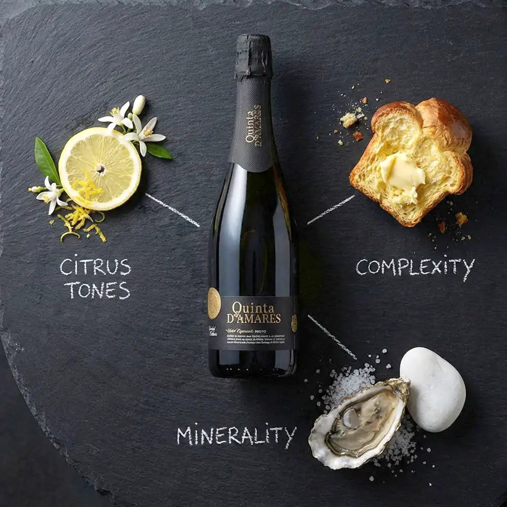 Bottle of Quinta d'Amare with lemon, bread, and oyster on a dark slate background