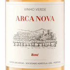 Close-up of a wine bottle label reading 'VINHO VERDE ARCA NOVA Rosé' with a black line drawing of a vineyard and buildings on an off-white background.