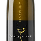 Close-up of a Conde Vilar Alvarinho wine bottle label, showing a dark olive-green glass body with a black and gold label featuring gold typography and a gold dotted graphic on a white background.