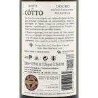 The back of a Quinta do Cótto Douro Reserva red wine bottle, showing the label text, wine details, and a WINESTONE guarantee seal on a dark bottle background.