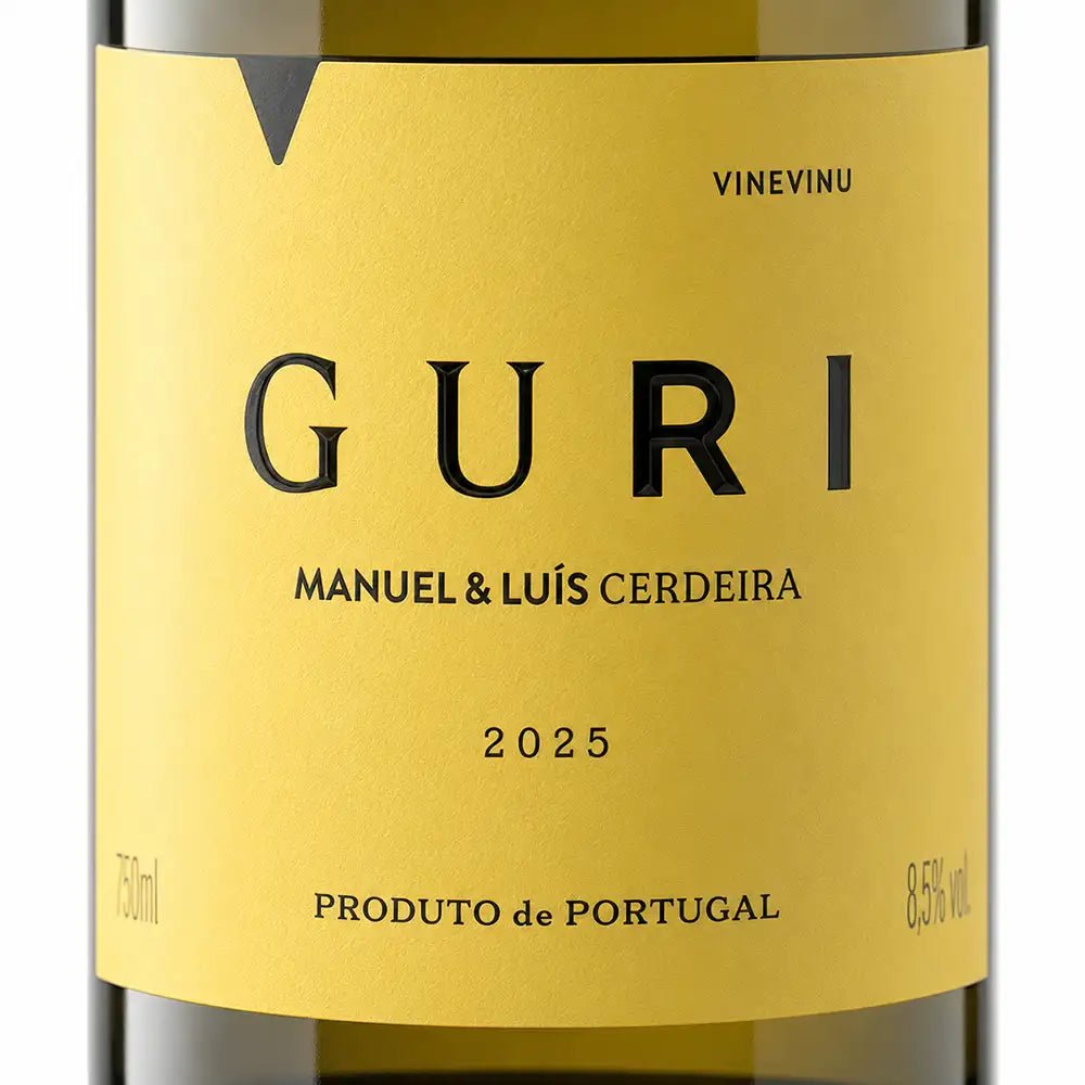 Close-up of a wine bottle label reading GURI, Manuel & Luis Cerdeira, 2025, with a mustard-yellow label and dark glass bottle visible at the top and bottom.