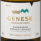 Close-up of a wine label reading GÉNESE with gold and teal logo elements on a white label, with dark brown bottle edges visible at the top and bottom.