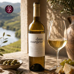 A bottle of duas margens white wine stands on a stone surface beside a filled wine glass, with olives, cheese, grapes, and an outdoor landscape visible in the background.