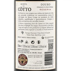 The back of a Quinta do Cótto Douro Reserva red wine bottle, showing the label text, wine details, and a WINESTONE guarantee seal on a dark bottle background.