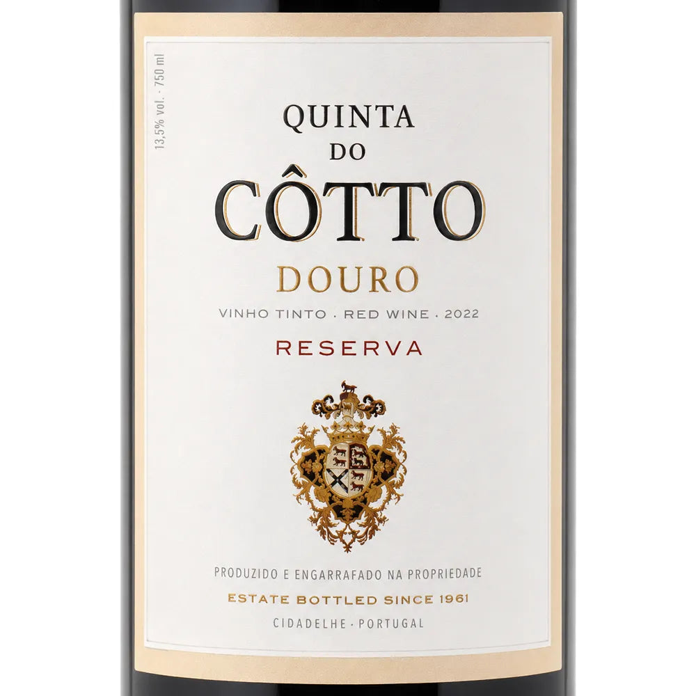 Front-facing wine bottle label for Quinta do Cotto Douro Reserva red wine, with a cream label, black and gold typography, and a decorative crest on a white background.