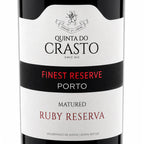 Close-up of a Quinta do Crasto wine bottle label, showing 'Finest Reserve Porto' and 'Matured Ruby Reserva' on a white and black label.