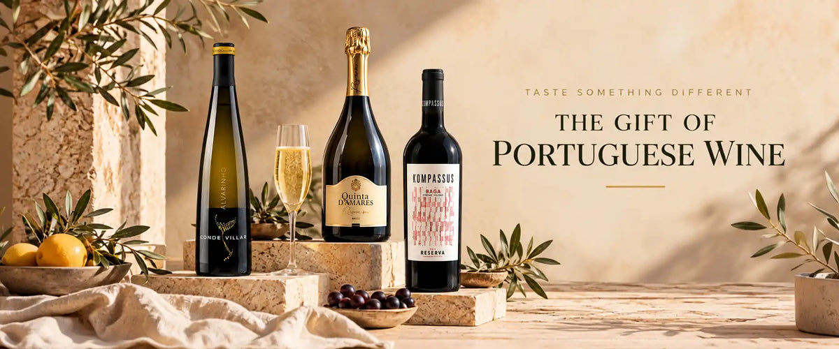 Three bottles of Portuguese wine and a glass of white wine are arranged on stone blocks with olives and lemons, against a warm beige background with the text 'THE GIFT OF PORTUGUESE WINE'.