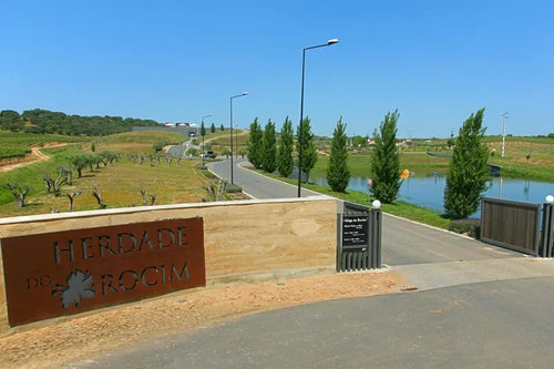 Entrance to Herdade do Rocim with a sign and surrounding landscape.