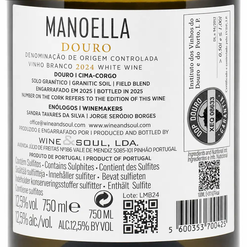 Close-up of a wine label reading MANOELLA DOURO, with Portuguese text, a barcode, QR code, and circular wine institute seal on a dark bottle background.